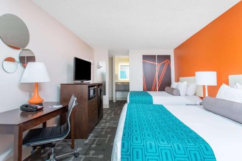a hotel room with two beds and a desk and a computer at Howard Johnson by Wyndham Ocala FL I-75 in Ocala