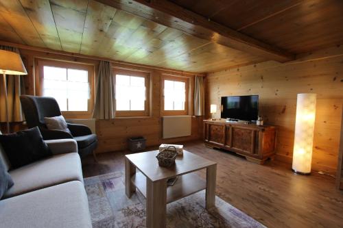 a living room with a couch and a tv at Les Mourriaux in Chateau-d'Oex