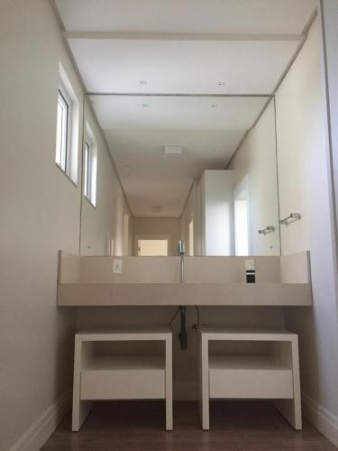 een badkamer met een grote spiegel en een wastafel bij Casa 450m2 Laguna Internacional in Laguna