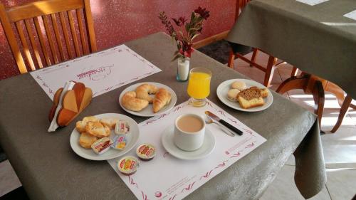 a table with plates of food and a cup of coffee at Hotel Escala Uno in Santo Tomé