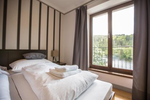 two beds in a room with a window at Hotel Mandát in Hradištko