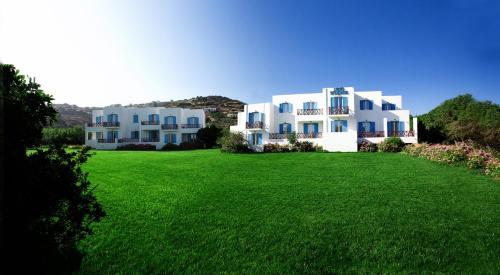 a large white building on top of a green field at Likio Studios in Batsi