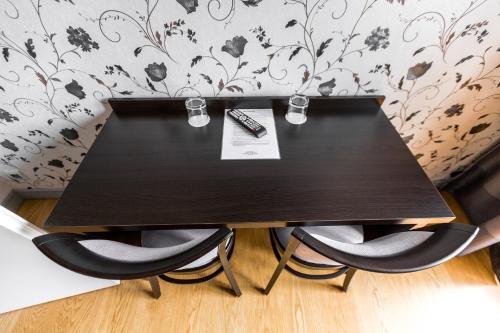 a black table with two chairs and a remote control at Hotel Mandát in Hradištko