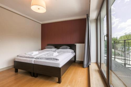 a bedroom with a bed and a large window at Hotel Mandát in Hradištko
