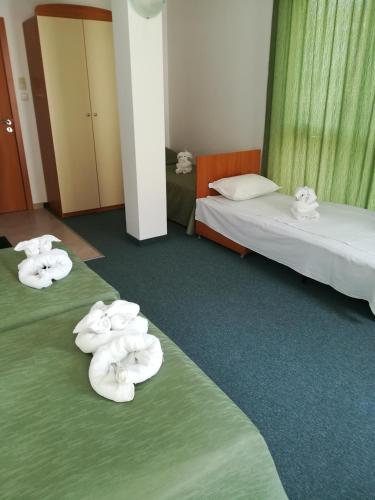 a hotel room with two beds with towels on them at Guesthouse Ruskovi in Ravda