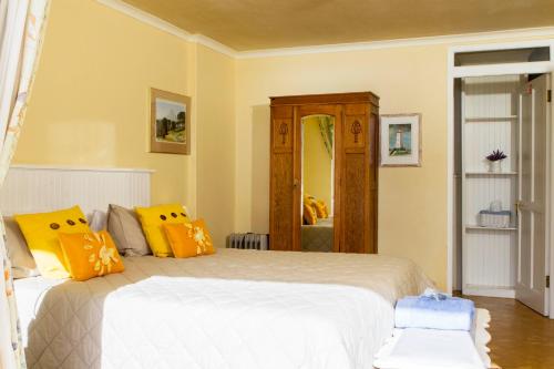 a bedroom with a large bed with yellow pillows at Albatross Guest House in Simonʼs Town