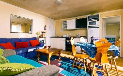 a living room with a blue couch and a table at Albatross Guest House in Simonʼs Town