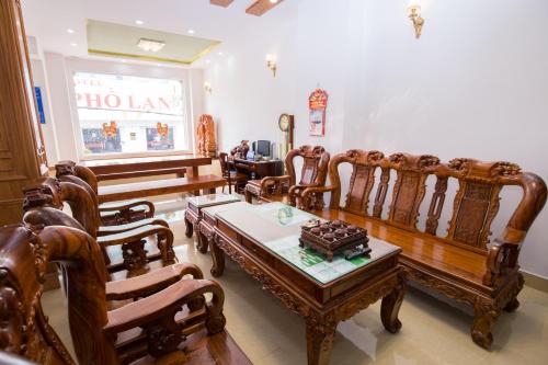 sala de estar con mesa y sillas de madera en Phu Tho Da Lat Hotel en Da Lat