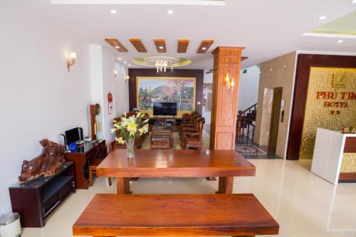 a living room with a table and a couch at Phu Tho Da Lat Hotel in Da Lat
