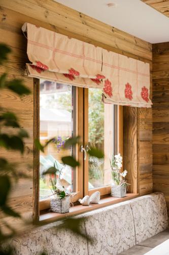 a window with a curtain and flowers on it at Hotel Lohningerhof in Maria Alm am Steinernen Meer