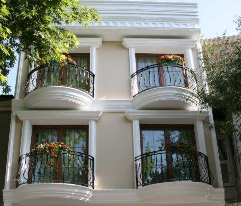 um edifício branco com duas varandas e flores nele em Kumsal Butik Otel em Istambul