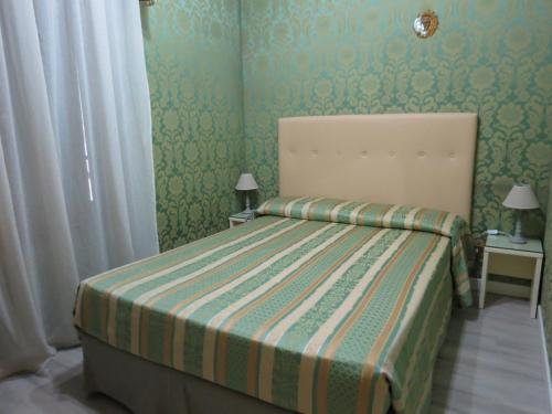 a small bedroom with a bed with a striped blanket at Hotel Bridge in Venice