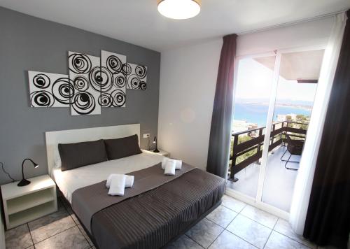 ein Schlafzimmer mit einem Bett und einem Balkon in der Unterkunft Domuum Holidays - PANORAMIC MONTEMAR in Salou