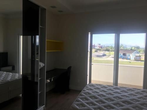 een kamer met een bed en een grote glazen deur bij Casa 450m2 Laguna Internacional in Laguna