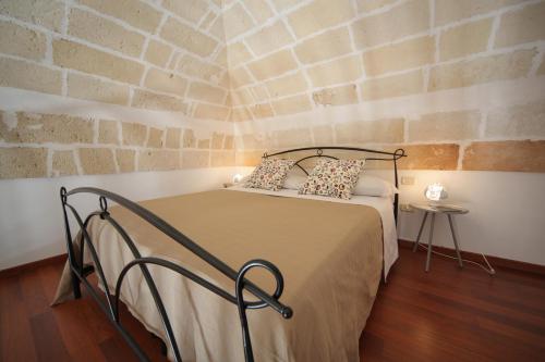 マンドゥーリアにあるLa Buona Creanzaのレンガの壁のドミトリールームのベッド1台分です。