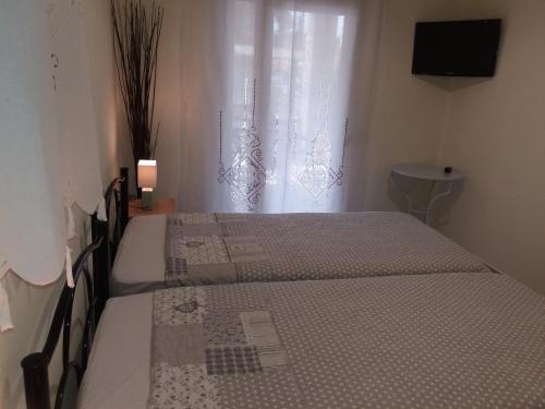 two beds in a room with a window at Villa Anna in Ayios Nikolaos Sithonia