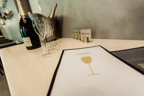 a table with wine glasses and a menu on it at Hotel Mandát in Hradištko