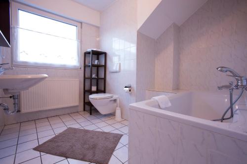 a bathroom with a tub and a toilet and a sink at Hotel Rhein-Ahr in Remagen