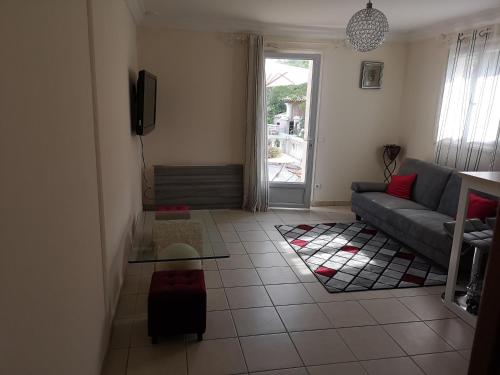 a living room with a couch and a tv at gîte de la Rose in Draguignan