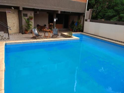 a large blue swimming pool with a table and chairs at La Familia Hotel in Puerto Iguazú