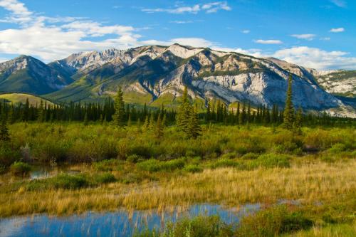 a view of a mountain range with a pond at Overlander Mountain Lodge in Jasper