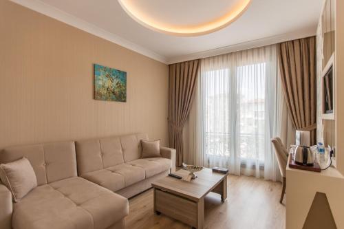 sala de estar con sofá y mesa en The Grand Mira Business Hotel, en Estambul