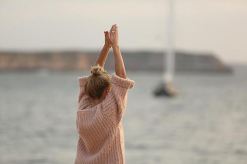 a woman holding her hands up in the air at Memmo Baleeira - Design Hotels in Sagres