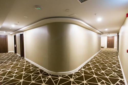 a large blank wall in a lobby with a tile floor at The Grand Mira Business Hotel in Istanbul