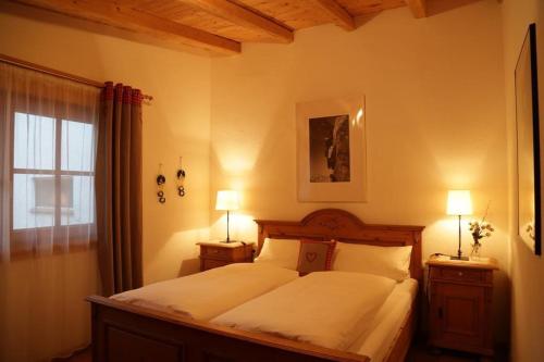 a bedroom with a bed with two lamps and a window at Ferienwohnung Angerer in Stumm