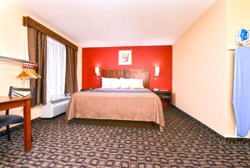 a hotel room with a bed and red walls at Americas Best Value Inn-Near NRG Park/Medical Center in Houston