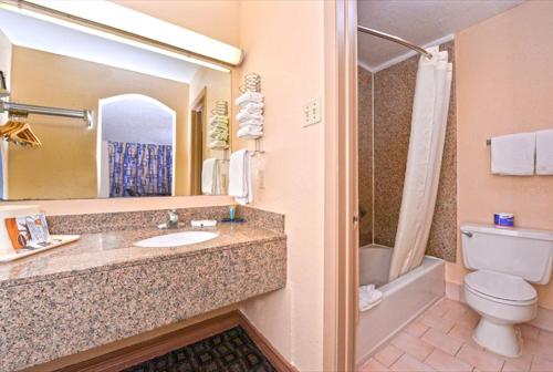 y baño con lavabo, aseo y espejo. en Americas Best Value Inn-Near NRG Park/Medical Center en Houston