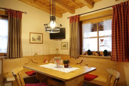 a dining room with a wooden table and a chandelier at Ferienwohnung Angerer in Stumm