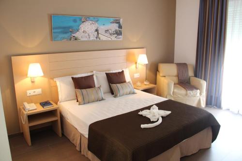 una habitación de hotel con una cama grande y una silla en Mena Plaza en Nerja