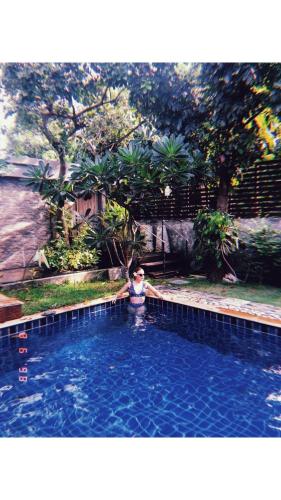 a person is standing in a swimming pool at Nature Home in Phra Nakhon Si Ayutthaya