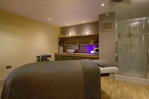 a bathroom with a shower and a bed and a sink at Drimsynie Estate Hotel in Lochgoilhead