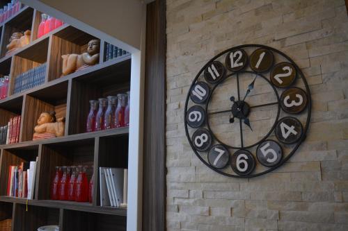 a clock on a brick wall next to a book shelf at BEST WESTERN Hotel Brussels South in Ruisbroek