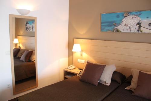 a hotel room with a bed and a mirror at Mena Plaza in Nerja