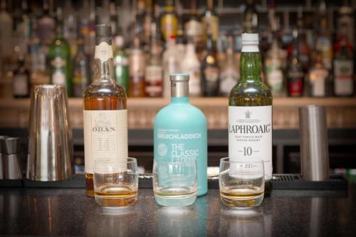 two bottles of alcohol and two glasses on a bar at Drimsynie Estate Hotel in Lochgoilhead