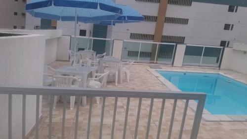 a patio with a table and chairs next to a pool at Pousada Beira Mar in Recife