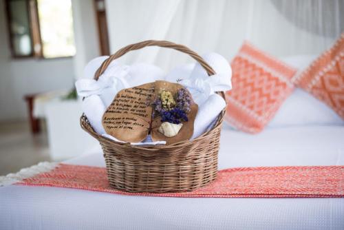 a basket filled with bread and flowers on a table at Hotel Casa Takywara in Holbox Island