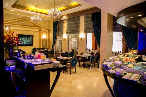 a restaurant with tables and people sitting at tables at Queens Suite Hotel in Beirut