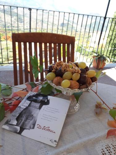 a bowl of fruit on a table with a sign at "Za' Vittoria" in Bomba