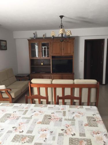 eine Küche und ein Wohnzimmer mit einem Tisch und Stühlen in der Unterkunft Casa Circular Norte in Nazaré