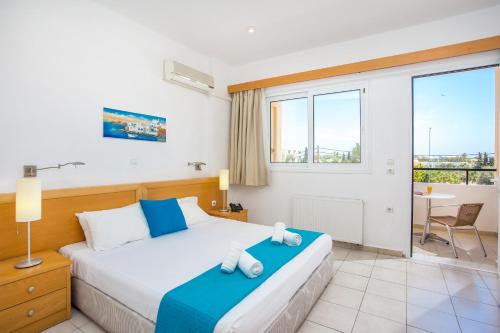 a bedroom with a bed and a large window at Mon Repos Hotel in Faliraki