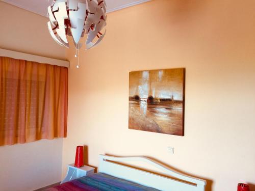 a bedroom with a bed and a chandelier at Villa Sofia in Chrani