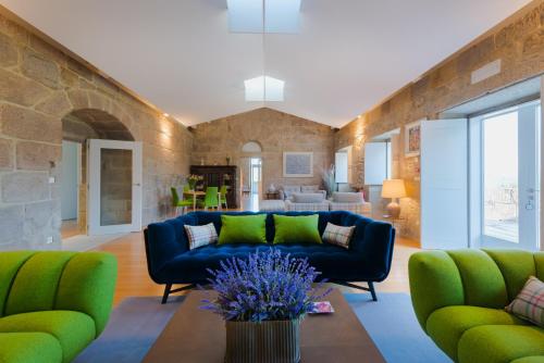 a living room with a blue couch and green chairs at Torre de Tebra in Tomiño