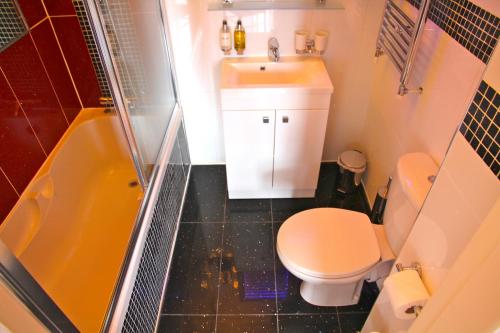 a bathroom with a toilet and a sink and a shower at Crompton Guest House in Hounslow