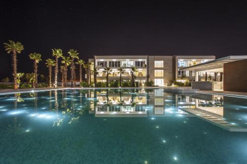 a swimming pool in front of a building at night at The View Bouznika in Bouznika
