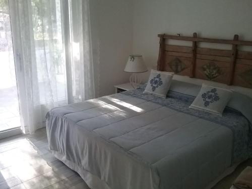 a bedroom with a large bed and a window at Villa Biancaluna in Carloforte