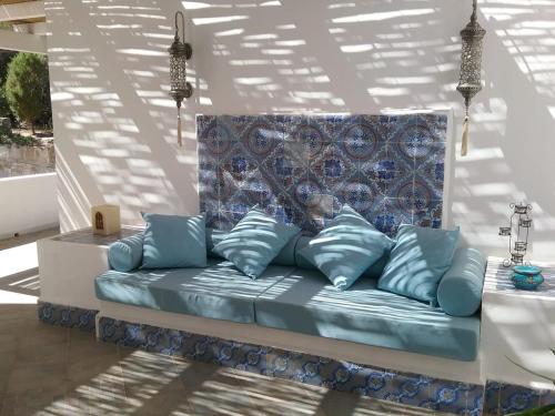a couch with blue pillows in a room at Villa Biancaluna in Carloforte